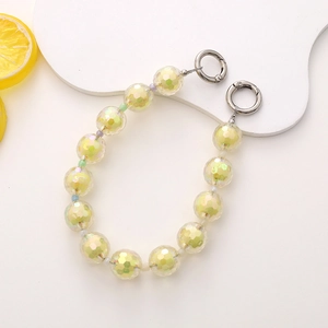Detail of colorful faceted acrylic beads with metallic spring ring clasps and lemon accent