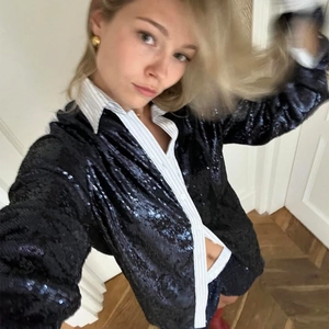 Detail view of women retro black sequin patchwork long sleeve shirt and matching shorts