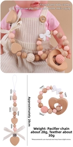 Detailed view of pink silicone and wooden baby pacifier clip set with bow and heart clip