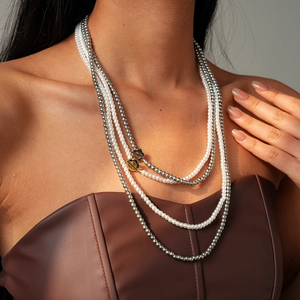 Detail of multi-layer layered faux pearl and metallic bead necklace with OT buckle clasp