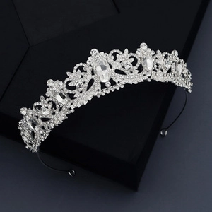 Detail of silver bridal crown with intricate vine patterns and shimmering rhinestones