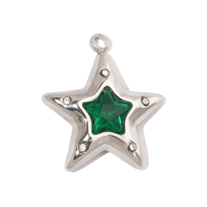 Macro shot of star-shaped pendant with green gemstone and zircon inlays on steel