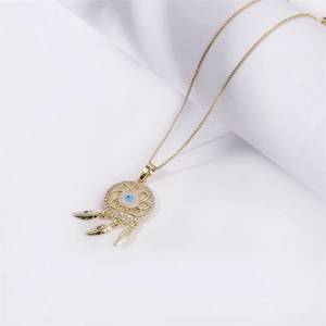 Collier attrape-rêves doré avec pendentif œil et glands plumes sur fond blanc épuré