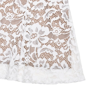 Detailed view of delicate white lace fabric with beige lining on a slim fishtail dress