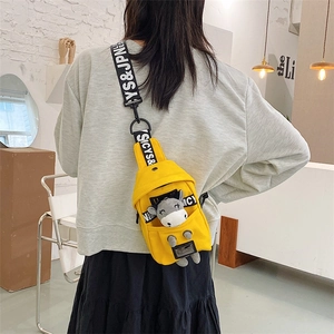 Detail of yellow canvas chest bag with cute plush donkey and lettered strap