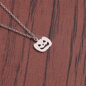 Silver stainless steel pumpkin pendant necklace with jack-o-lantern face on wood