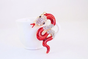 Detailed close-up of a red enamel snake keychain with sparkling crystal rhinestones
