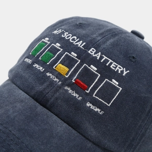 Detailed view of 'MY SOCIAL BATTERY' embroidery on a washed cotton baseball cap
