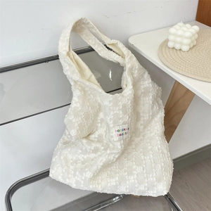 Détail du sac cabas en jacquard blanc avec texture florale 3D et tissu tissé élégant