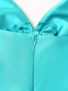 Détail du zip invisible et du tissu en satin brillant sur la robe élégante bleue