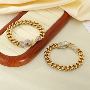 Detail of gold Cuban chain bracelet featuring diamond snake head with red and green eyes
