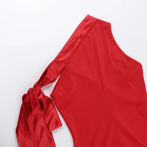 Détail d'une robe rouge à épaule dénudée avec nœud en satin et texture de tissu mat