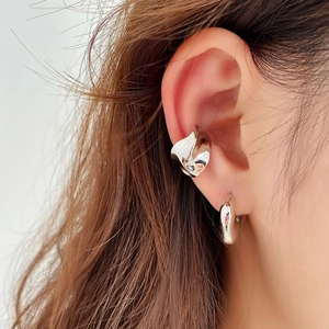 Macro di un ear cuff e orecchino in argento sterling S925 indossati sull'orecchio