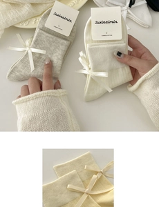 Detail of sweet cream socks with satin ribbon bows made from premium combed cotton