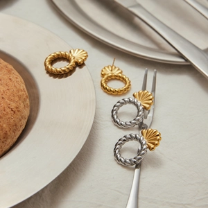 Dettagli di orecchini a cerchio ritorto in oro e argento con accenti di conchiglia