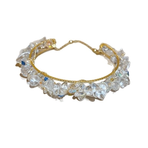 Bracciale vintage francese dorato con cristalli e perle blu su sfondo bianco neutro