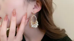 Boucles d'oreilles vintage en or avec cristaux et perles portées par un mannequin
