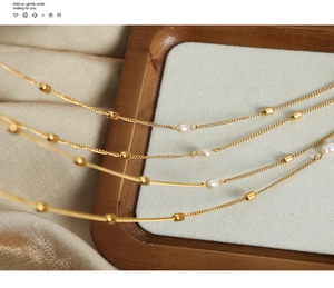 Detailed macro view of an 18k gold plated titanium chain with freshwater pearls