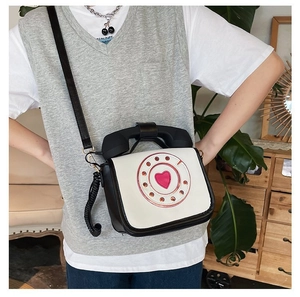 Unique quirky telephone shaped crossbody bag in black and white PU leather shown on model