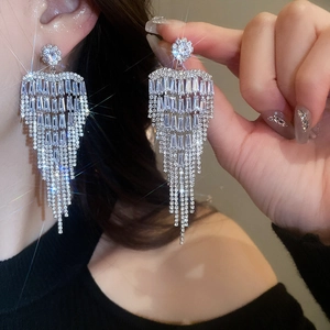 Macro shot of sparkling silver flower tassel earrings with brilliant cubic zirconia gems