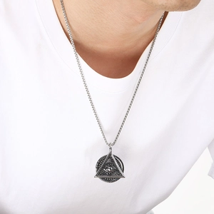 Detailed close-up of retro silver Eye of Providence pendant with round box chain on model