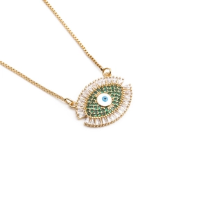 Macro detail of gold plated Evil Eye necklace with green cubic zirconia and box chain