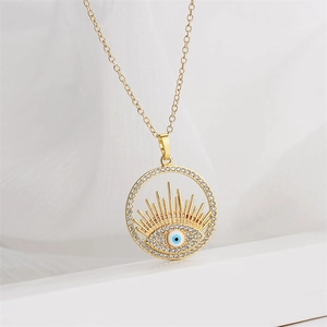 Gros plan d'un collier doré avec pendentif œil protecteur orné de zircons brillants