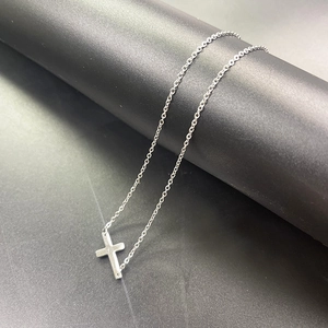 Dettaglio della collana a croce orizzontale in acciaio inossidabile argento con perle