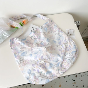 Detailed flat lay of floral canvas tote bag with purple flower oil painting texture
