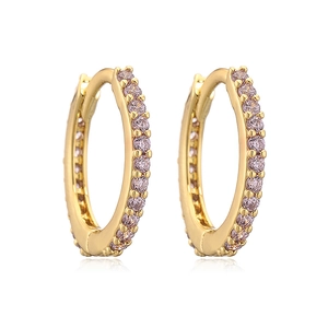 Detail of gold hoop earrings with row-set pink round-cut gemstones on white background