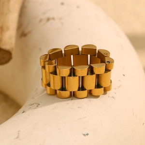 Detailed close-up of a gold-plated stainless steel ring with creative watchband design
