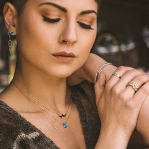 Close-up of bohemian gold jewelry set with turquoise pendants and zircon rings