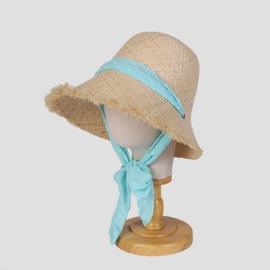 Lafia straw sun hat with light blue polka dot chiffon ribbon on a display stand