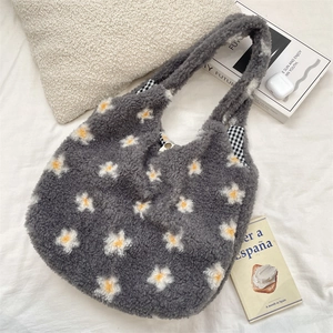 Détail du cabas en peluche grise avec marguerites brodées et doublure à carreaux