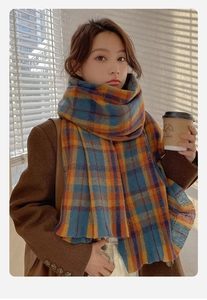 Detailed texture of thick blue orange plaid scarf in cozy light and shadow