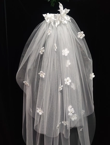Close-up of white bridal veil featuring delicate 3D flowers and pearls on soft mesh fabric