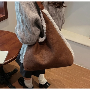 Brown faux suede tote bag with white faux fur trim shown in a cozy cafe setting