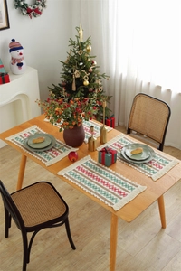 Detail of woven table runner with red and green geometric patterns and fringed edges