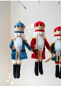 Close-up of velvet fabric nutcracker soldier ornaments with glitter details for Christmas tree