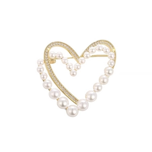 Golden heart brooch with white pearls and sparkling zircons on white background