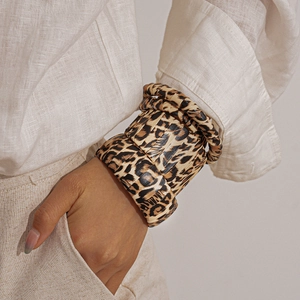 Close-up of leopard print layered bangle bracelets on model in bohemian style