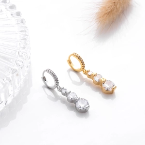 Detail of elegant gold and silver drop earrings with sparkling cubic zirconia crystals