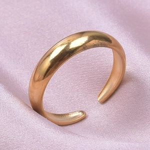 Polished gold adjustable stainless steel geometric ring on pink silk fabric background