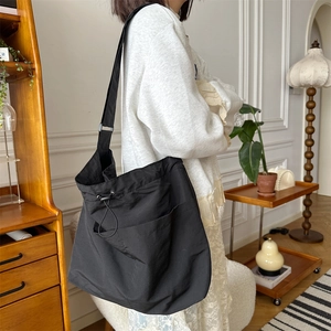 Borsa a tracolla nera capiente con design a coulisse e ampia tracolla regolabile