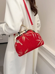 Red New Chinese-style handbag with bird and bamboo leaf embroidery shown on a model