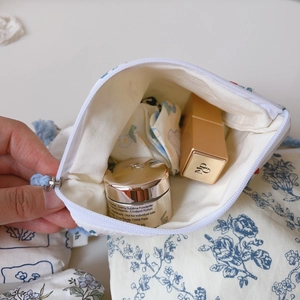 Detailansicht der blauen Blumen-Baumwolltasche mit Platz für Lippenstift und Creme