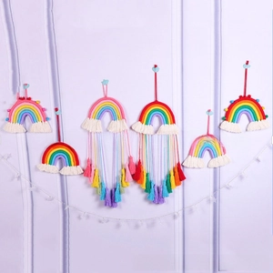 Detail of colorful handmade cotton rainbow wall hangings with tassels and wood beads