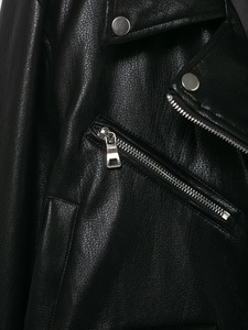Close-up of black leather biker jacket showing metallic zippers and textured fabric