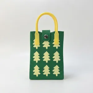 Detail of green knit handbag with yellow Christmas tree pattern and top handle