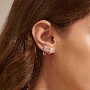 Primo piano di ear cuff a fiore in argento 925 con zirconi scintillanti sull'orecchio
